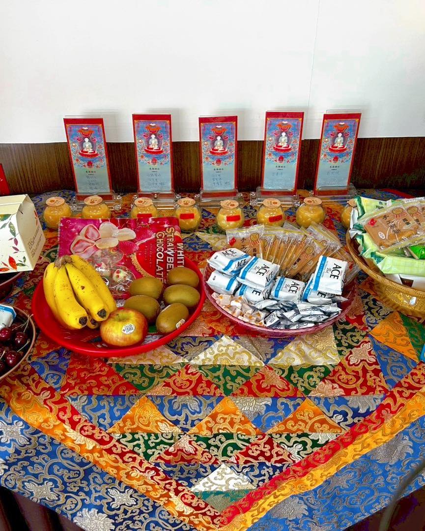 彩色桌布上的水果、飲品與包裝供品特寫。