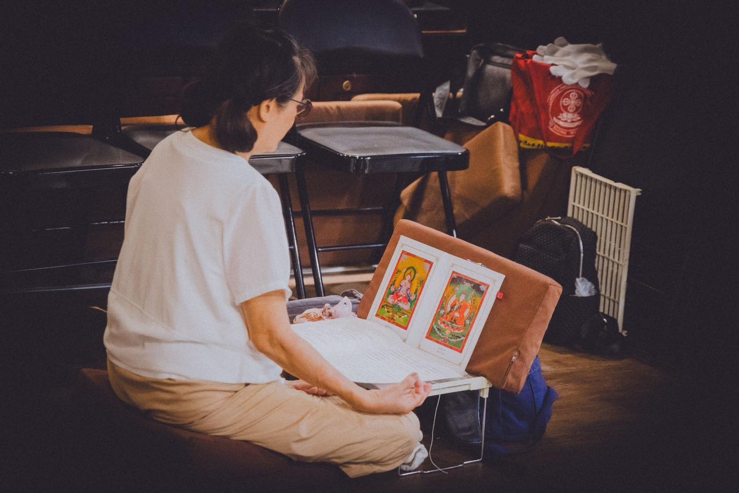 一位參與者坐在桌前閱讀攤開的彩色書頁。