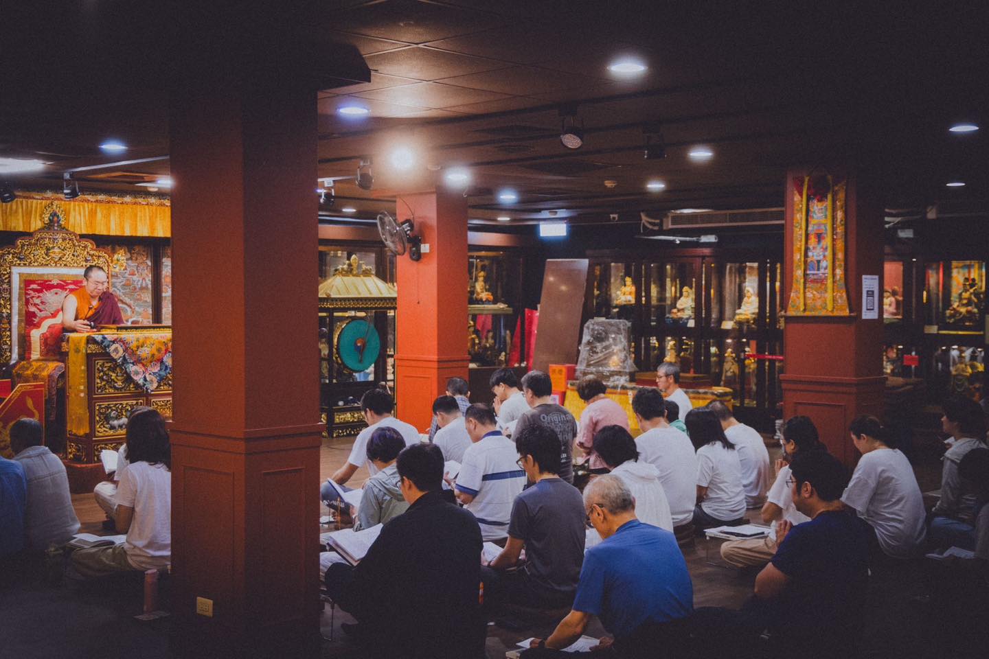 佛堂中央的供壇與席地聆聽的參與者。