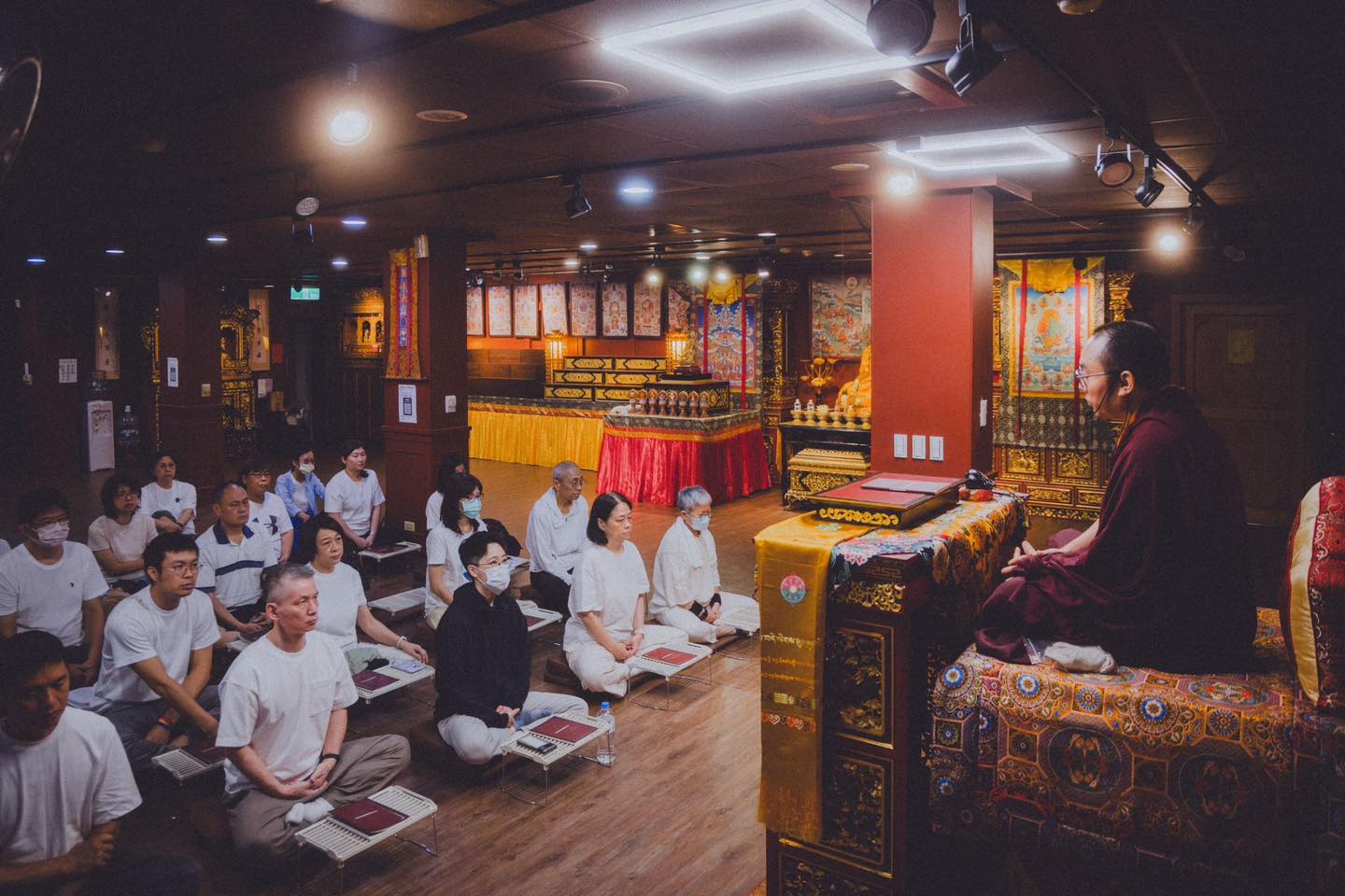 寬闊佛堂內,多位參與者席地共修。
