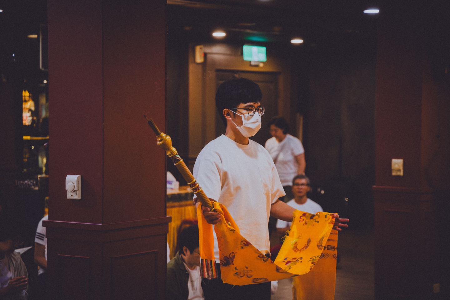 一位參與者拿著麥克風在供壇前發言。