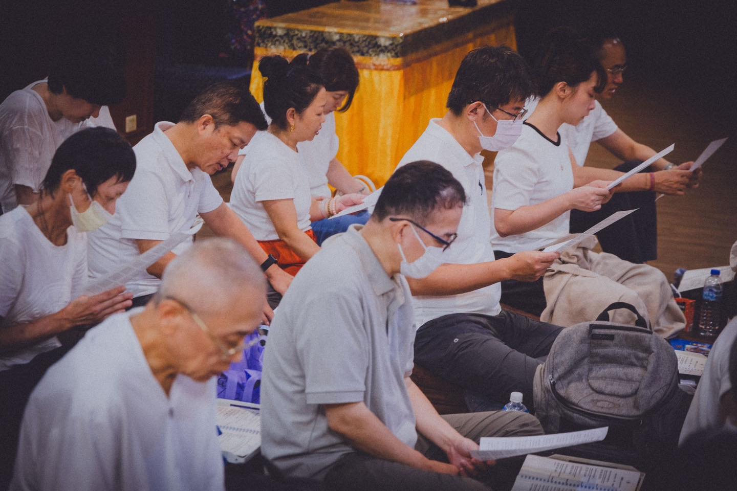 參與者在供壇旁接受穿袈裟者遞出的物品。