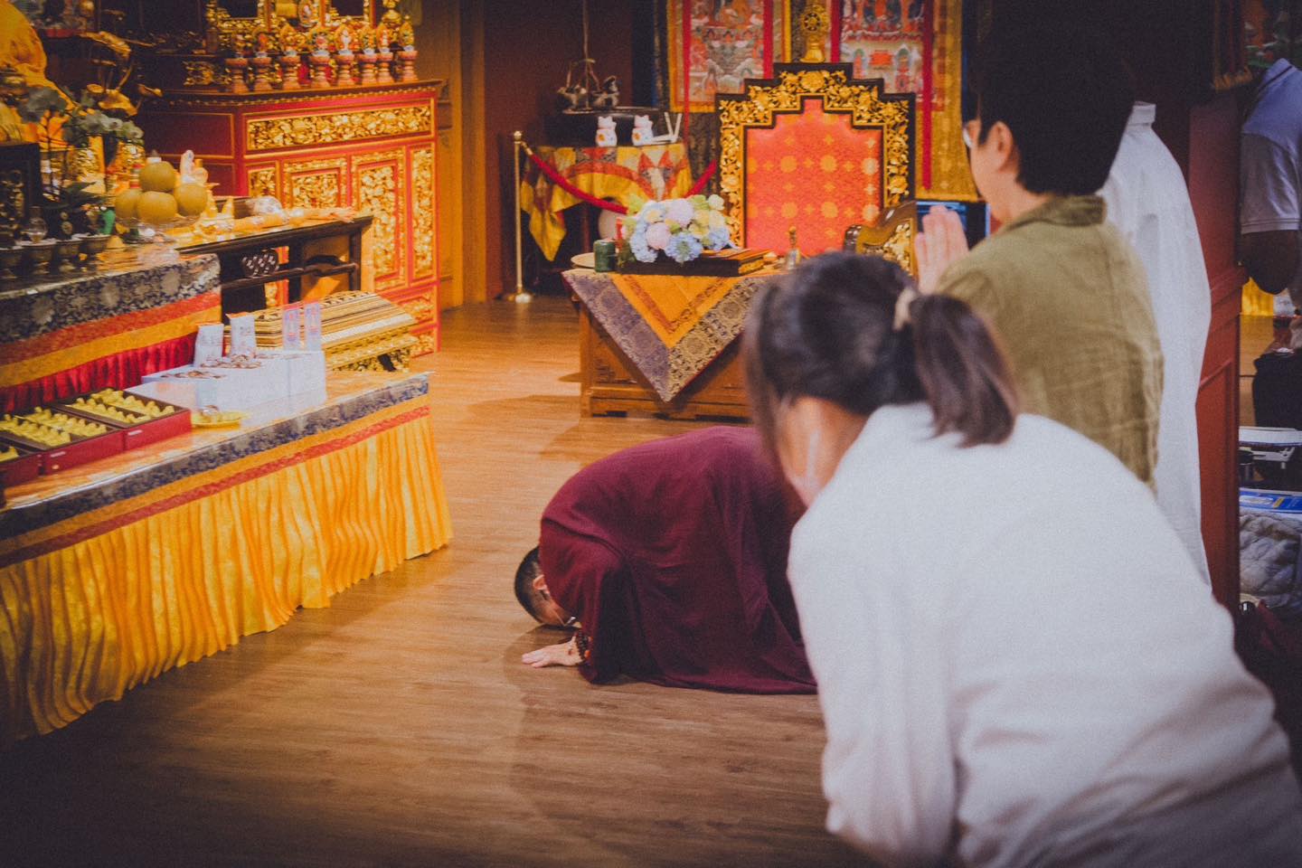 一位參與者在供壇前持紙本誦讀。