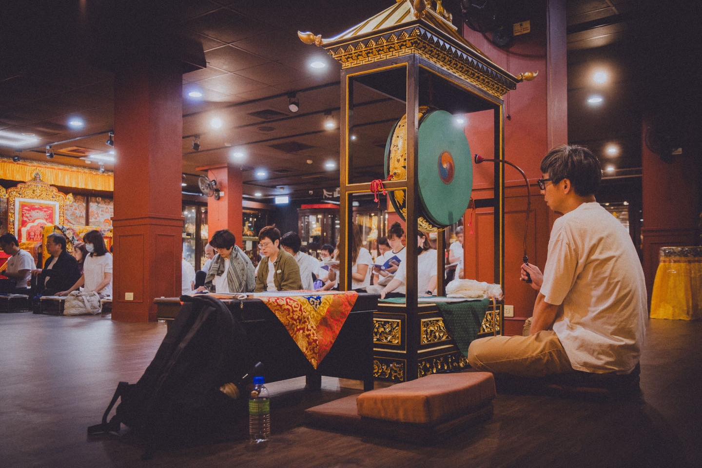 穿袈裟者在供壇前面向一位參與者。
