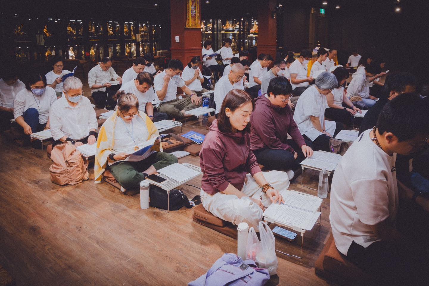 佛堂內，多位參與者席地閱讀。