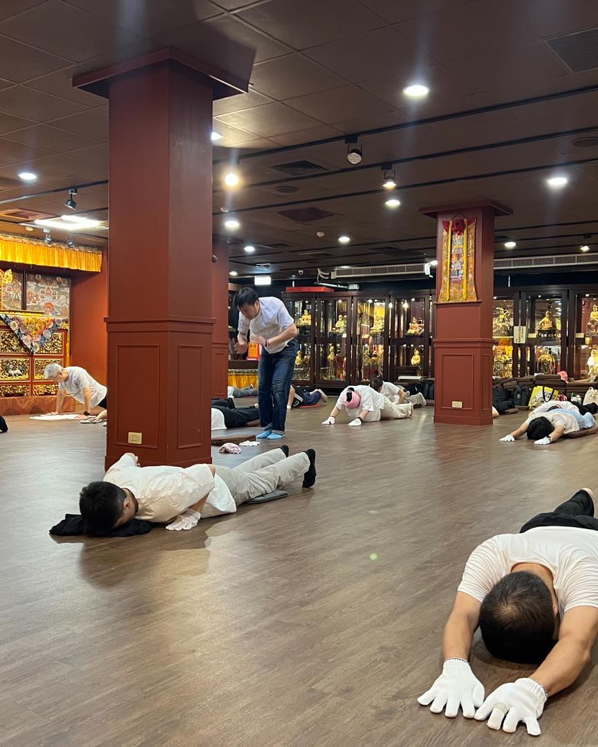佛堂地板上,參與者俯身禮拜,後方可見供壇。