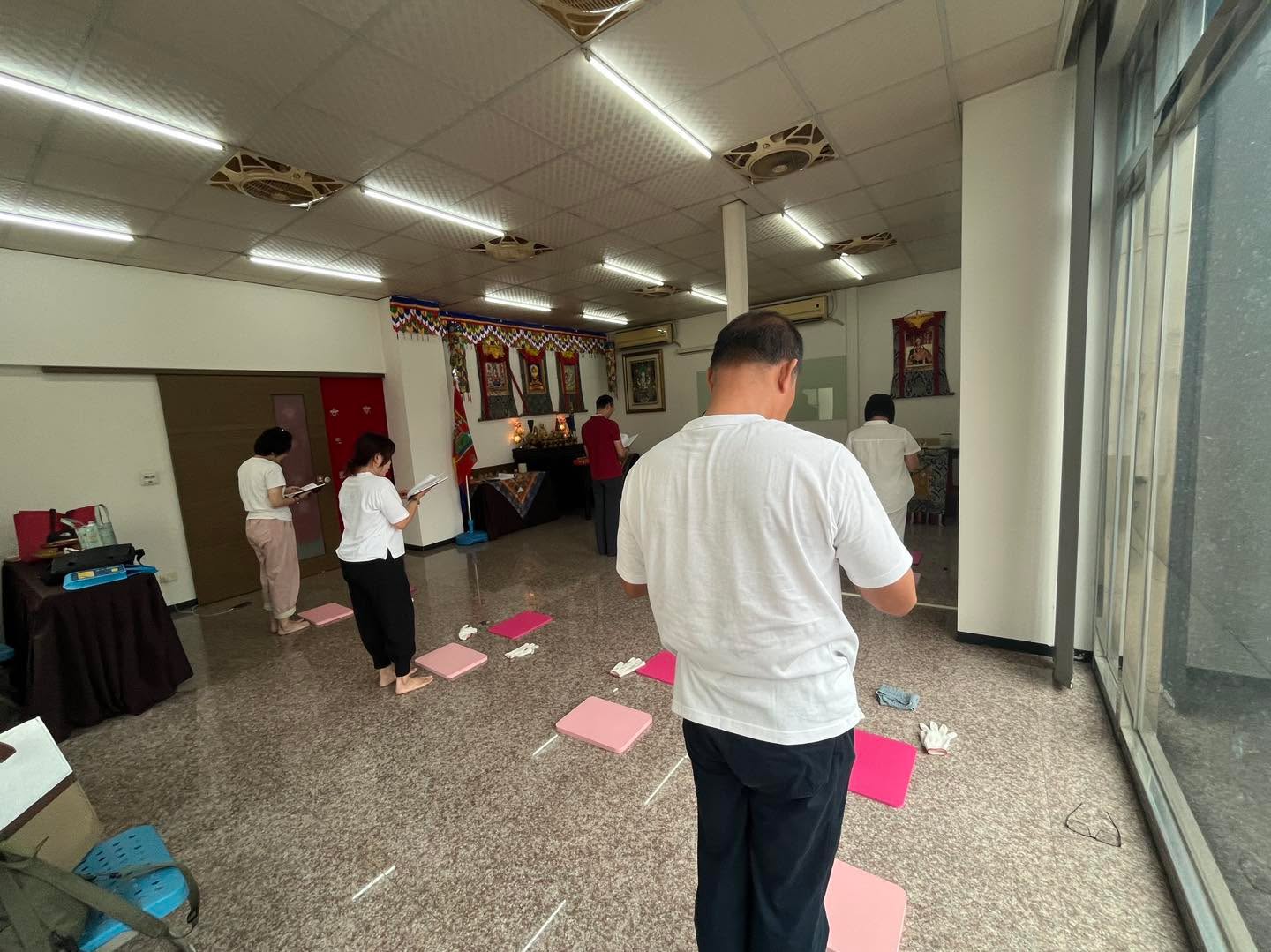 從後方拍攝，參與者在室內跪墊前靜立。